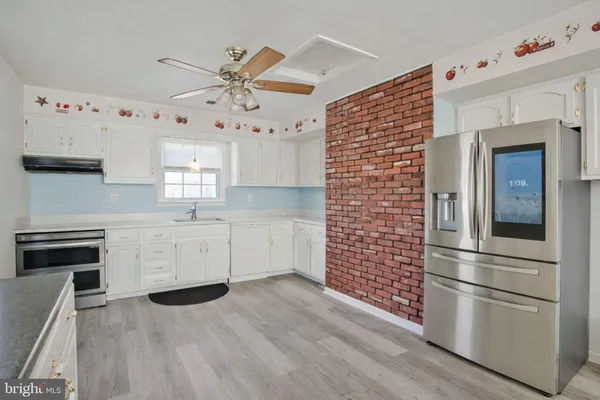 a kitchen with granite countertop white cabinets and stainless steel appliances