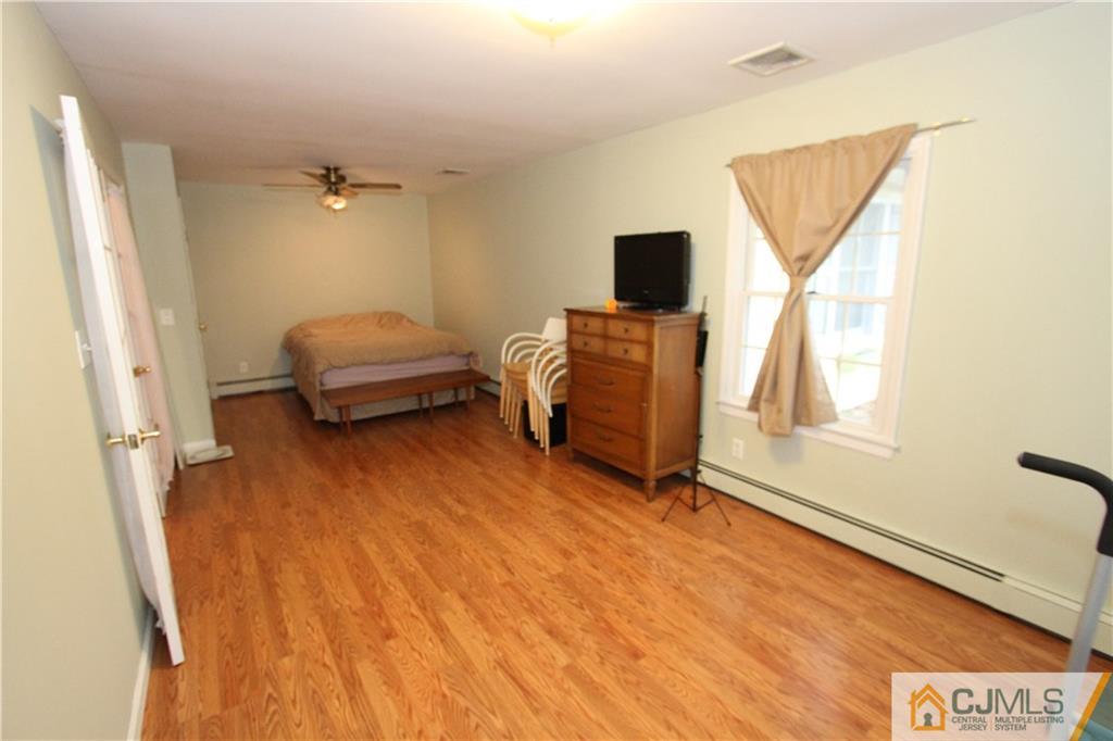 30 Brookville Road Edison, NJ 08817 - Photo 11 of 25 a bedroom with a bed and a flat screen tv