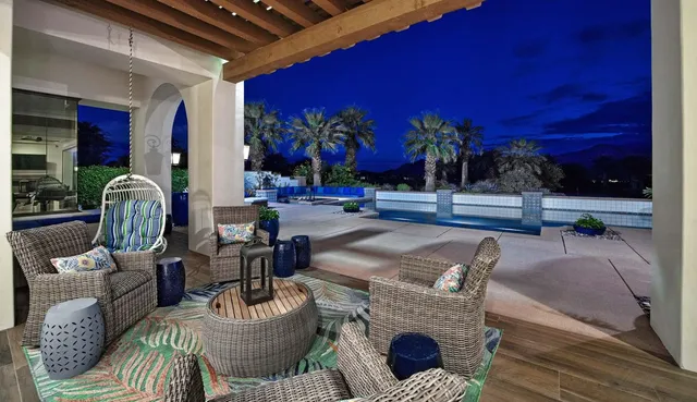 a view of a patio with dining table and chairs with plants and a barbeque