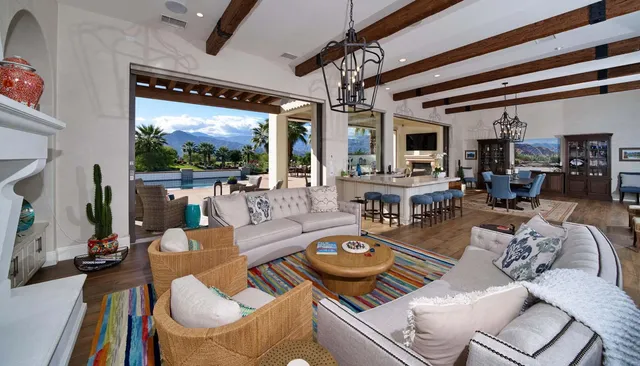 a living room with furniture a flat screen tv and floor to ceiling window