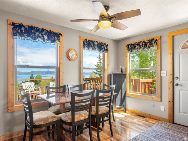 371 Lewis Loop, Unit 29 Fish Haven, ID 83287 - Photo 25 of 40 Dining area featuring wood-finish flooring, a ceiling fan with integrated lighting, and multiple windows with natural wood trim