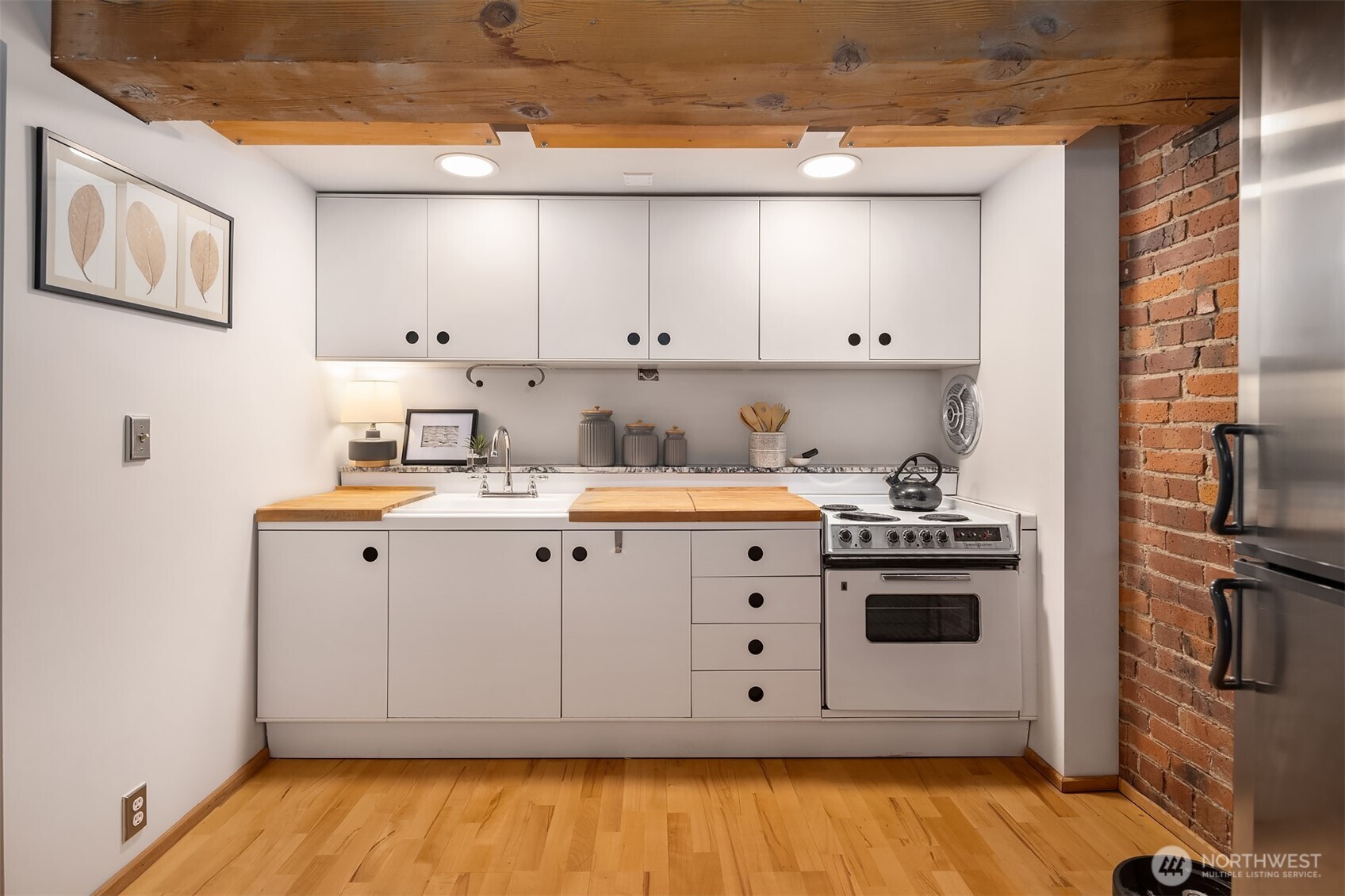 1507 Western Avenue, Unit R501 Seattle, WA 98101 - Photo 3 of 35 a kitchen with cabinets and wooden floor