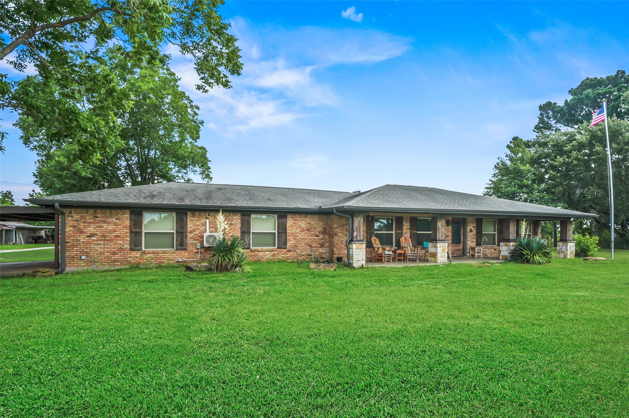34366 Owens Road Hempstead, TX 77445 - Photo 4 of 46 Ranch-style home with a sprawling front lawn, mature shade trees, and inviting country charm in a peaceful rural setting.