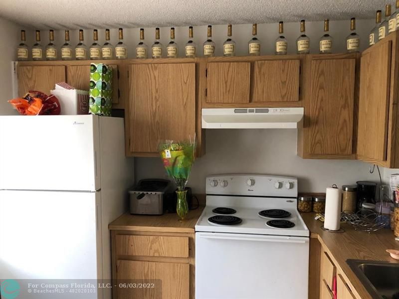 8540 Sherman Circle North, Unit 302 Miramar, FL 33025 - Photo 11 of 18 a kitchen with a sink a stove and refrigerator