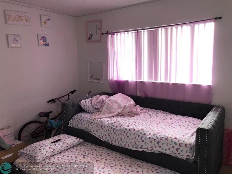 8540 Sherman Circle North, Unit 302 Miramar, FL 33025 - Photo 15 of 18 a bedroom with a bed and wooden floor