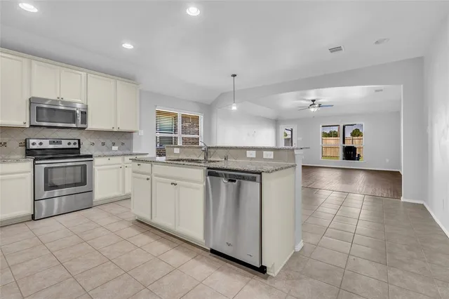 a kitchen with stainless steel appliances granite countertop a stove a sink and a refrigerator