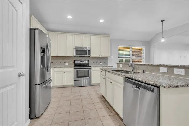 a kitchen with stainless steel appliances granite countertop a refrigerator sink and cabinets