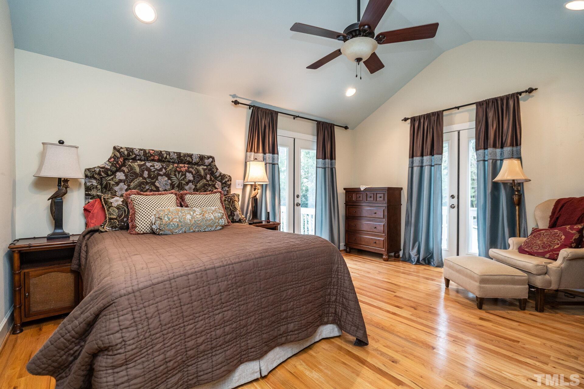 2204 West Charlotte Court Raleigh, NC 27607 - Photo 12 of 31 a bedroom with a bed and a chandelier