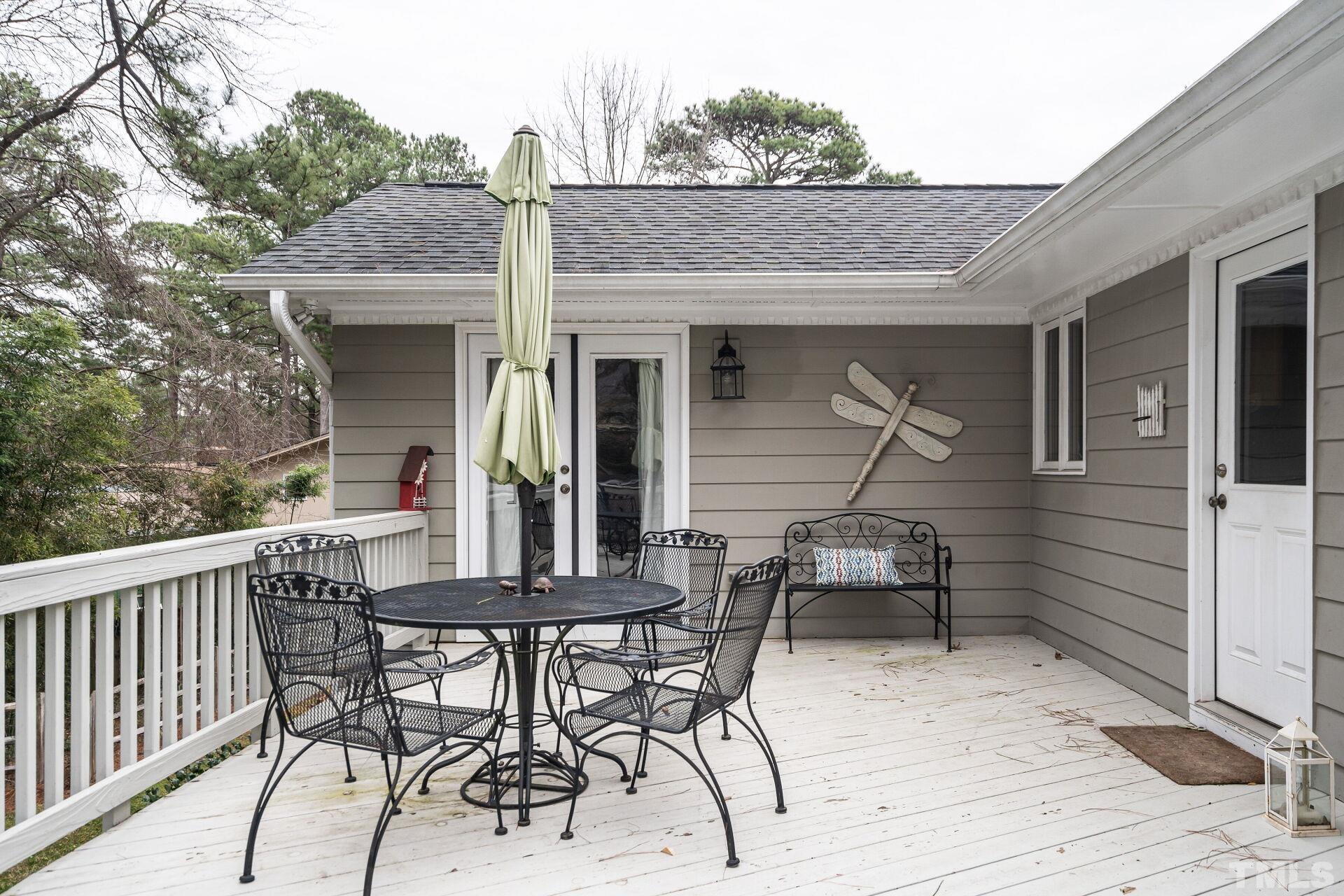 2204 West Charlotte Court Raleigh, NC 27607 - Photo 26 of 31 a view of a patio with table and chairs with wooden floor and fence