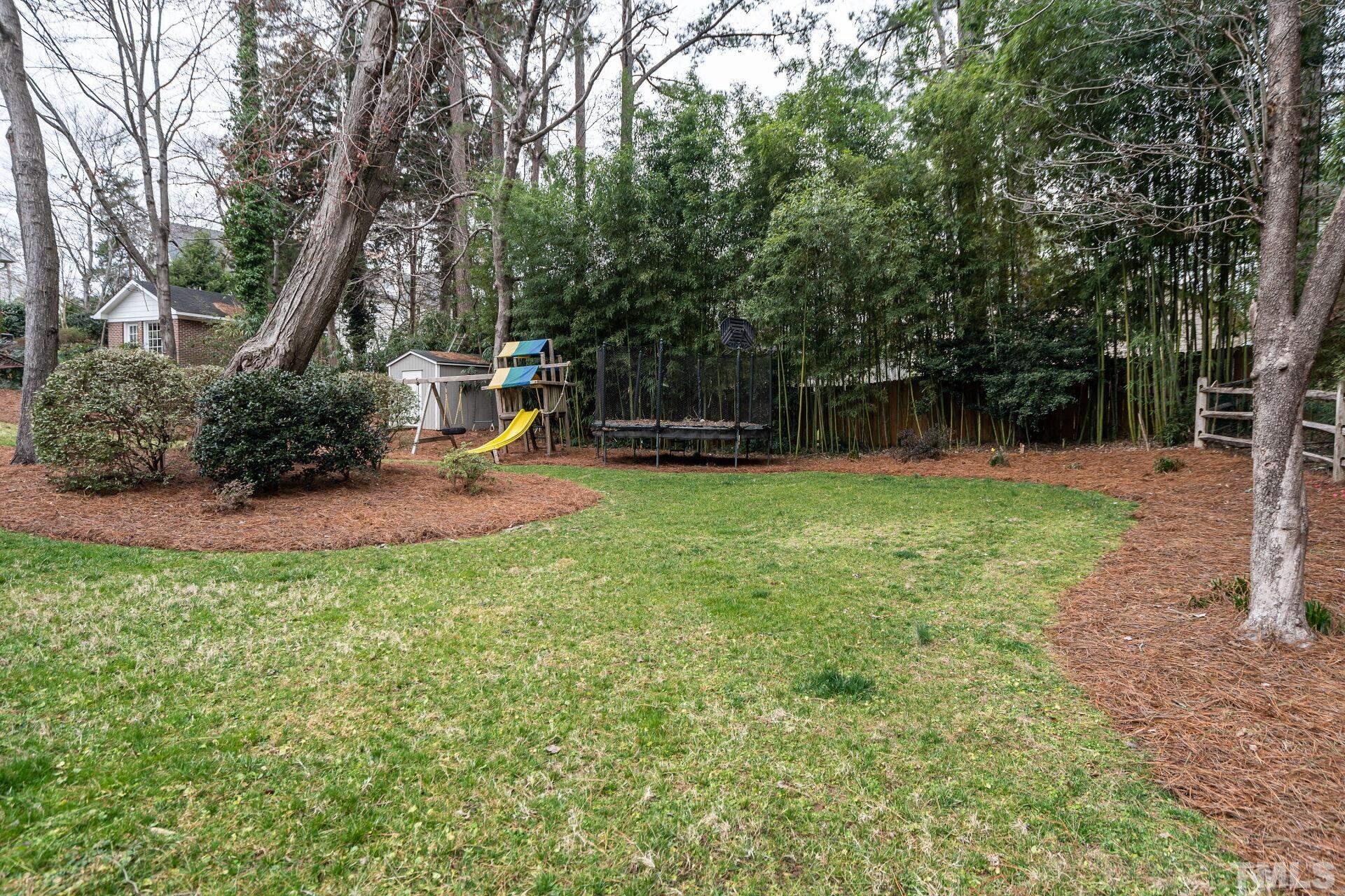 2204 West Charlotte Court Raleigh, NC 27607 - Photo 31 of 31 a view of a backyard with plants and large trees
