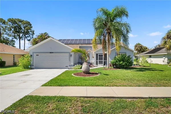 a front view of a house with a garden and yard