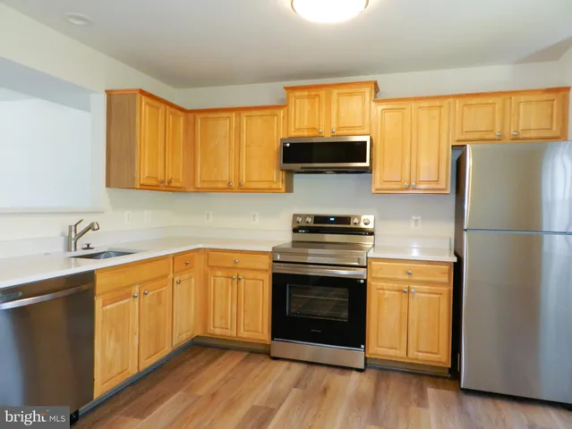 a kitchen with stainless steel appliances a stove sink and refrigerator