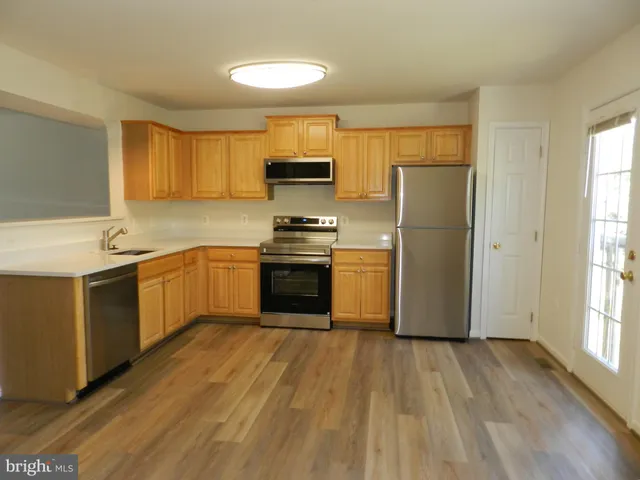 a kitchen with a sink a window stainless steel appliances and cabinets