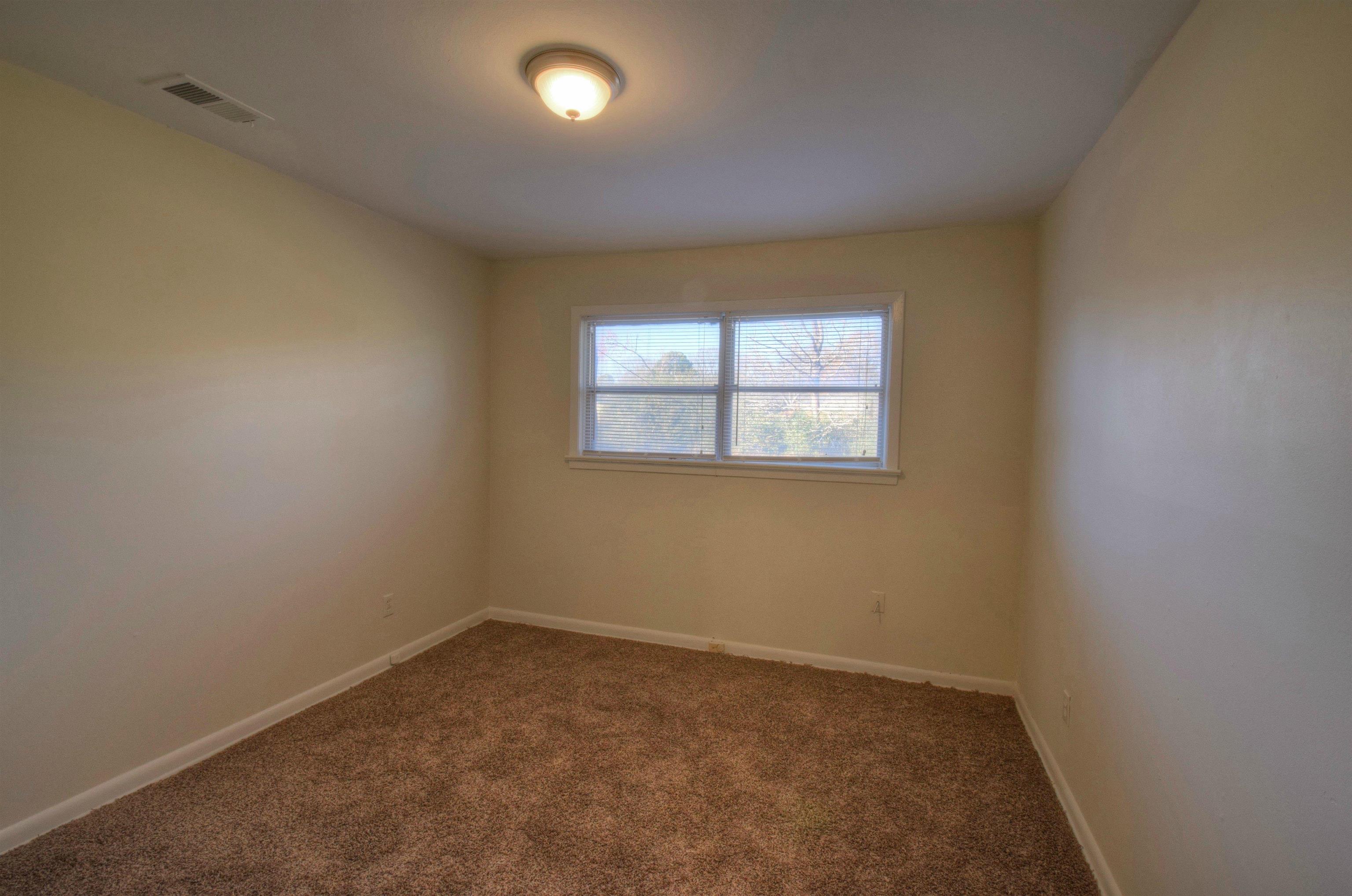 954 East Holmes Road Memphis, TN 38116 - Photo 3 of 11 Spare room featuring carpet flooring