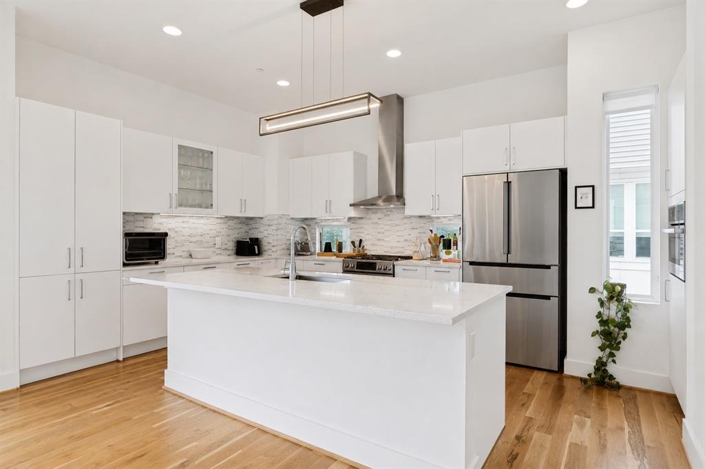 1952 Kearney Court Dallas, TX 75204 - Photo 11 of 24 a kitchen with stainless steel appliances a refrigerator sink and white cabinets