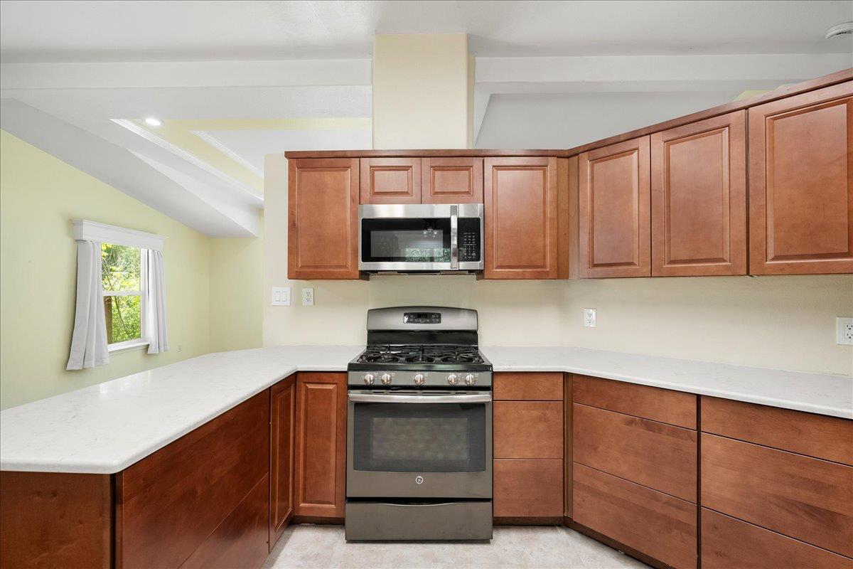 21819 Todd Valley Road Foresthill, CA 95631 - Photo 13 of 37 a kitchen with granite countertop a stove a microwave and cabinets