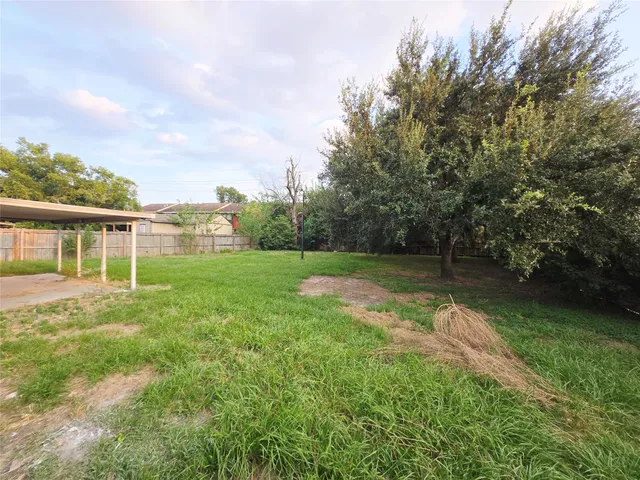 a view of a house with a backyard and a tree