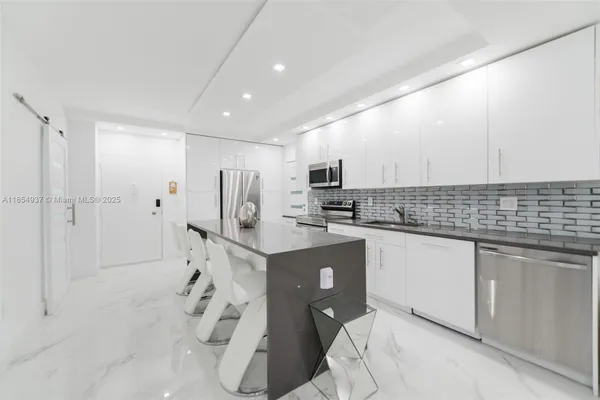 a kitchen with white cabinets a sink stove and refrigerator