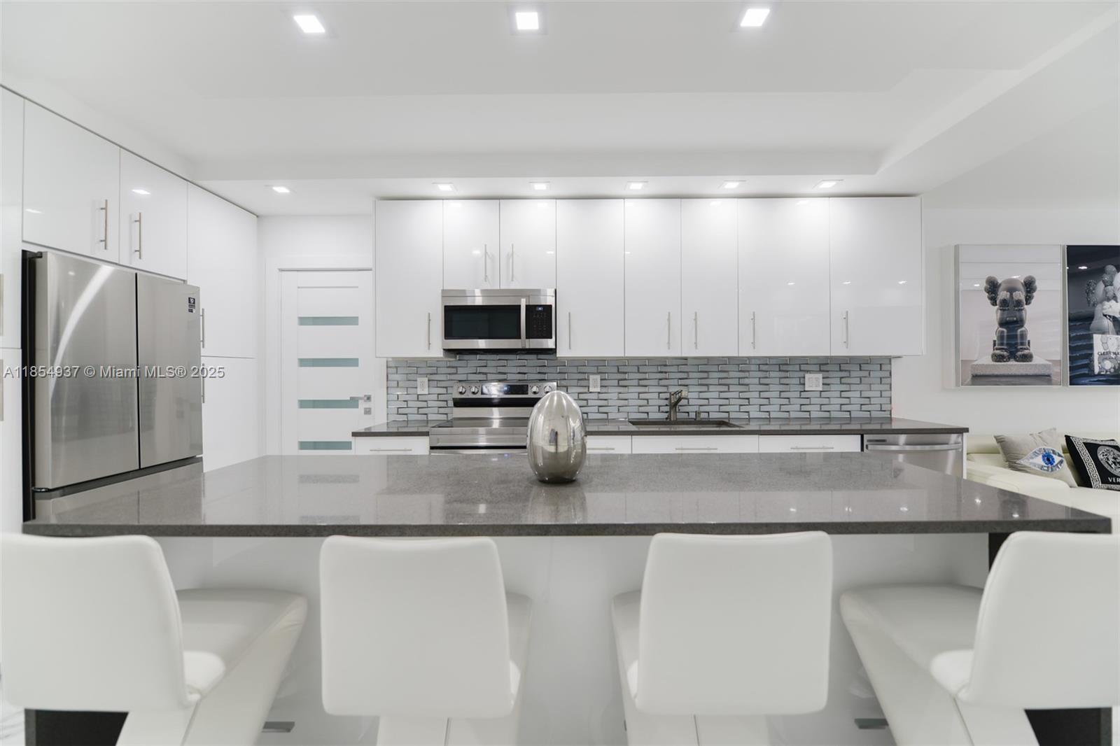 1980 South Ocean Drive, Unit PHM Hallandale Beach, FL 33009 - Photo 5 of 18 a kitchen with stainless steel appliances a sink a stove a microwave a refrigerator a counter top space and cabinets