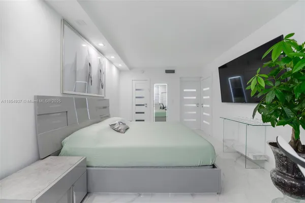 a bedroom with a bed and a potted plant