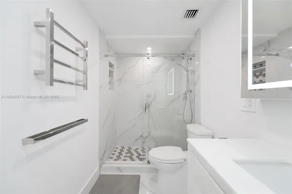 a bathroom with a sink a toilet and shower
