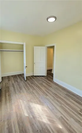 an empty room with wooden floor and a window