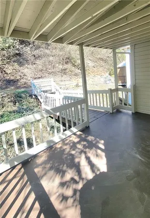a view of a porch with a bench in wooden floor
