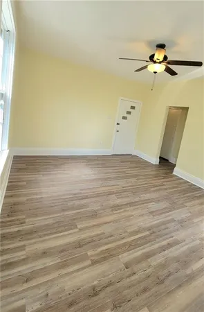 a view of a room with wooden floor and a ceiling fan