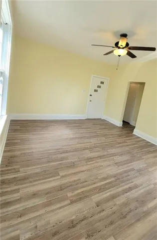 a view of a room with wooden floor and a ceiling fan