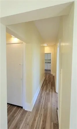 a view of a hallway with wooden floor and closet