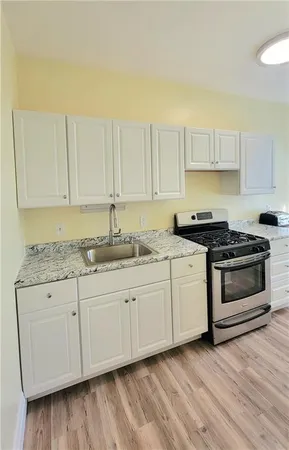 a kitchen with granite countertop white cabinets and white appliances