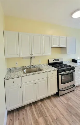 a kitchen with granite countertop white cabinets and white appliances