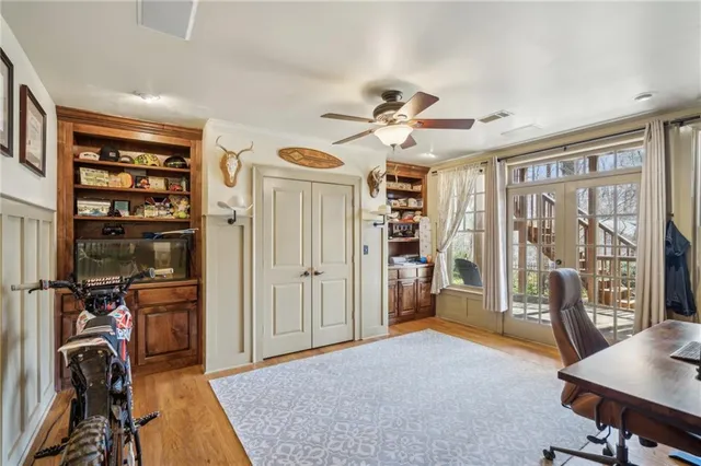 a view of a backyard with potted plants and large trees