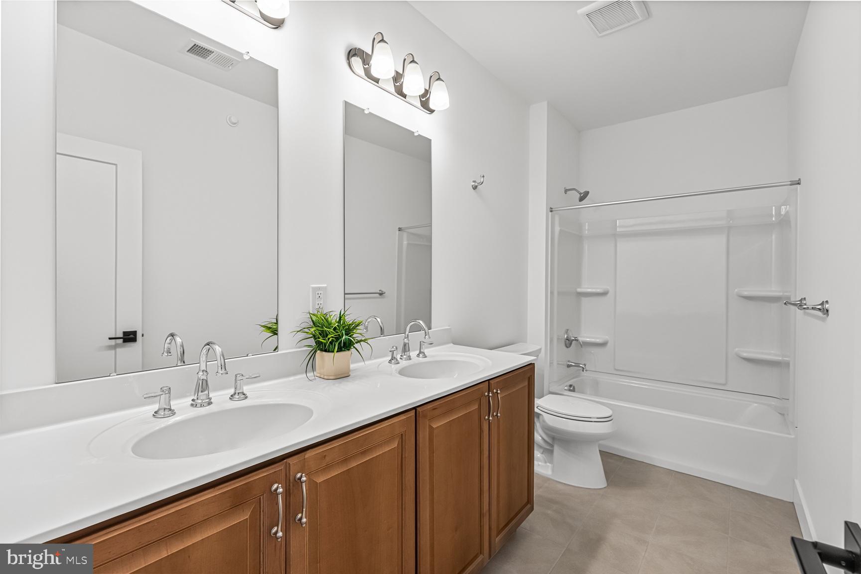 10206 Donatello Drive Princeton, NJ 08540 - Photo 27 of 30 a bathroom with a double vanity sink toilet mirror and bathtub