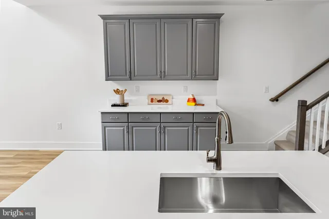 a kitchen with stainless steel appliances a sink dishwasher a stove with wooden floor