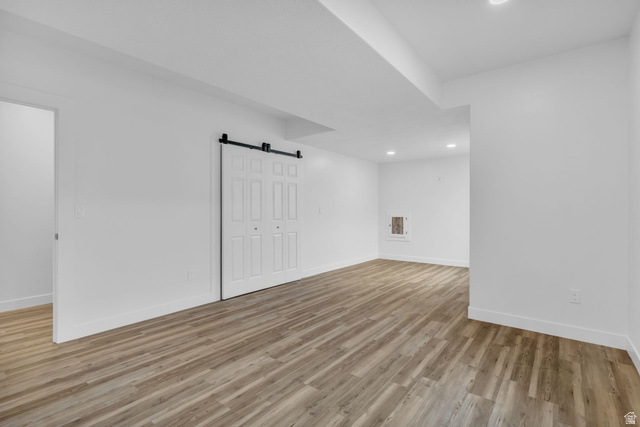 2454 West Jackson Street Mapleton, UT 84664 - Photo 36 of 63 Bedroom featuring a barn door, light wood-style floors, and recessed lighting