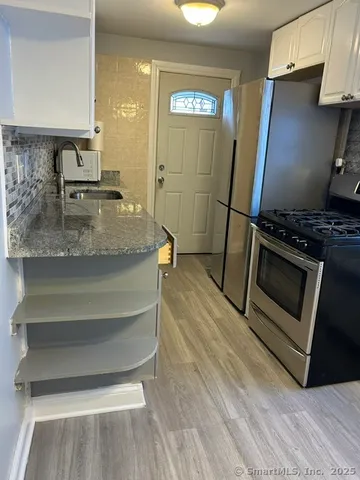 a kitchen with granite countertop a stove and a refrigerator