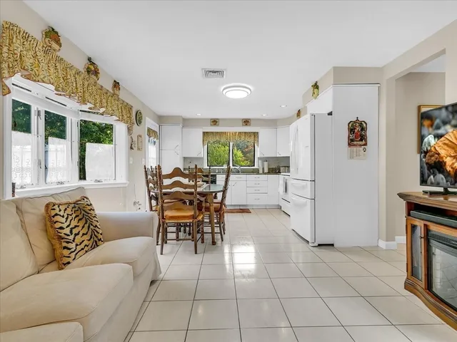 a living room with furniture a dining table and a fireplace