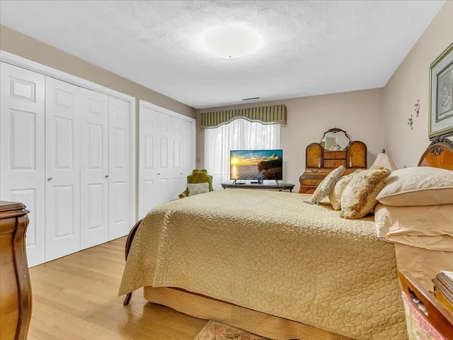 a bedroom with a bed and a painting on the wall