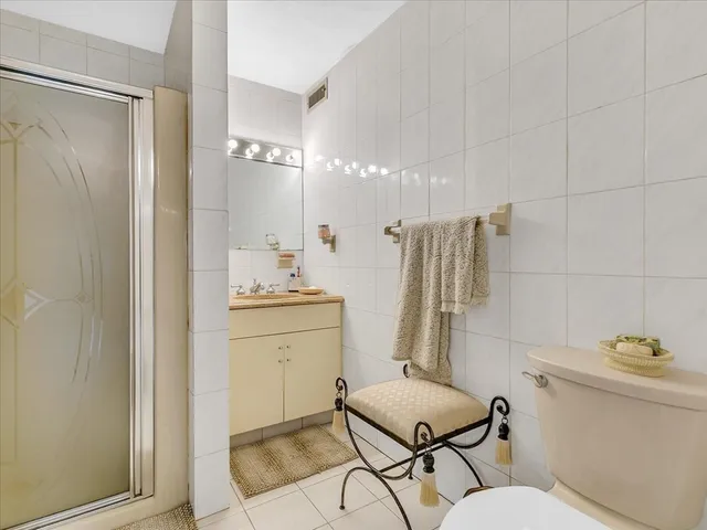 a bathroom with a granite countertop sink and a toilet