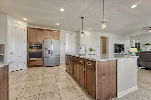 a kitchen with stainless steel appliances kitchen island granite countertop a refrigerator and a sink