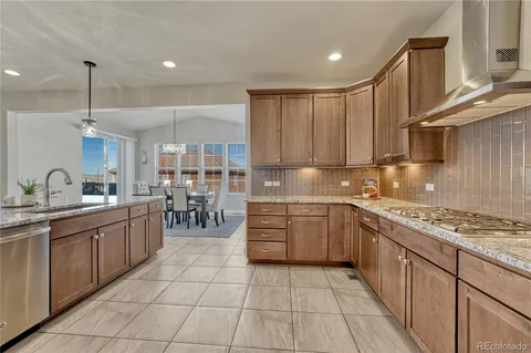 a kitchen with kitchen island granite countertop a sink counter top space appliances and cabinets