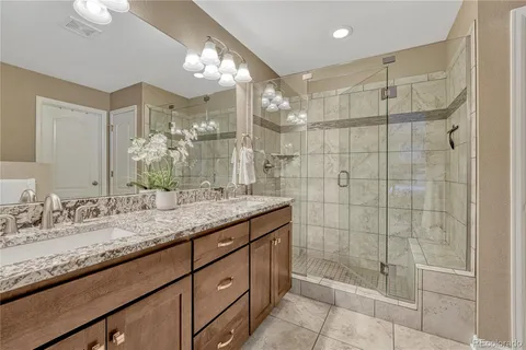 a bathroom with a granite countertop shower sink and mirror