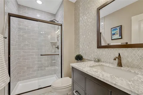 a bathroom with a granite countertop sink toilet and shower