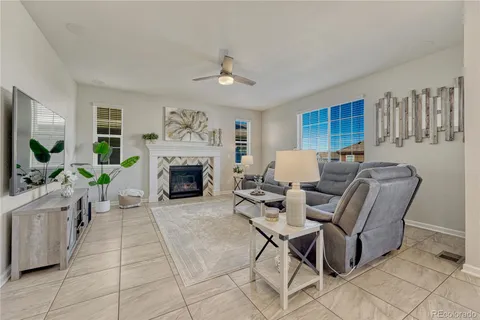 a living room with furniture a large window and a fireplace