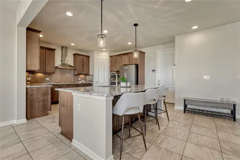 a kitchen with stainless steel appliances kitchen island granite countertop a sink and a refrigerator