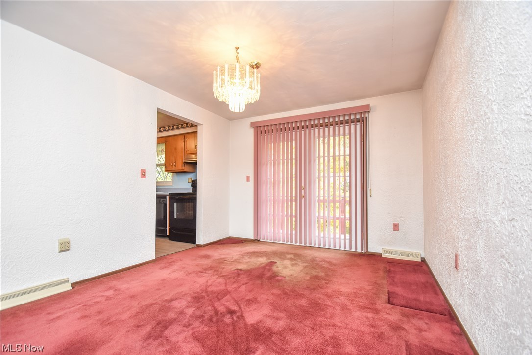 47700 Summerset Road East Liverpool, OH 43920 - Photo 9 of 35 Empty room with light carpet, a baseboard heating unit, and a chandelier