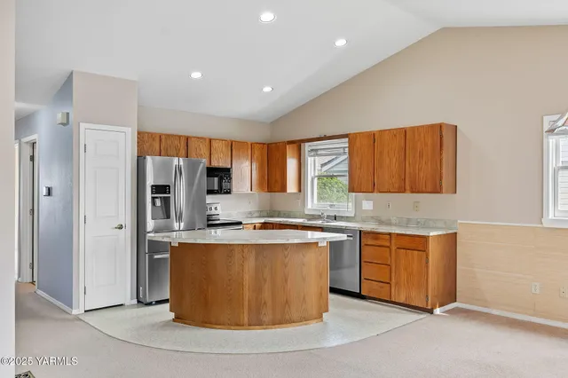 a kitchen with stainless steel appliances granite countertop a stove a sink a refrigerator and a refrigerator