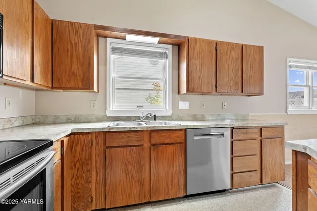 a kitchen with granite countertop cabinets sink and window
