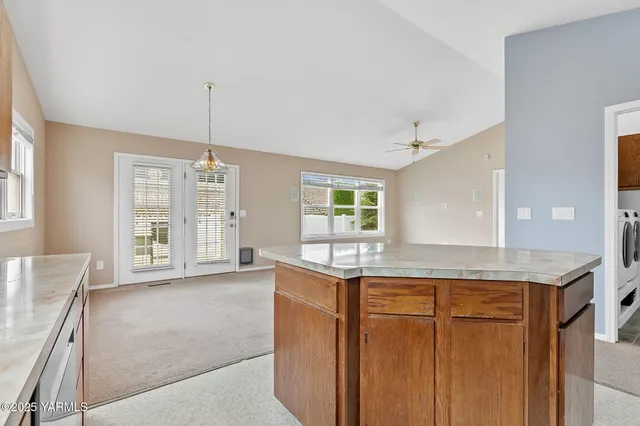 a kitchen with kitchen island granite countertop a sink and cabinets